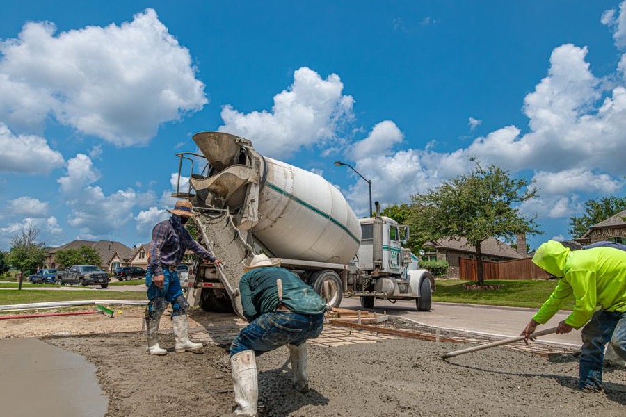 Concreting crew screeding freshly poured concrete off a mixer truck